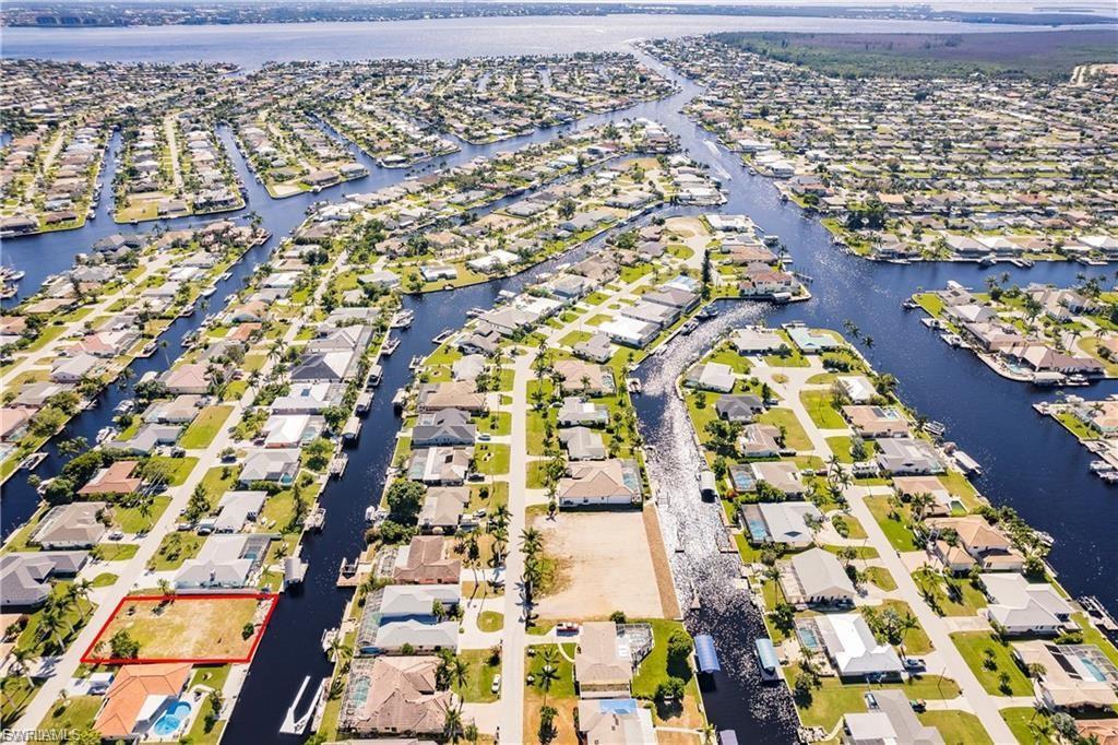 Image 3: Aerial view of residential area with a large body of water and property boundaries highlighted