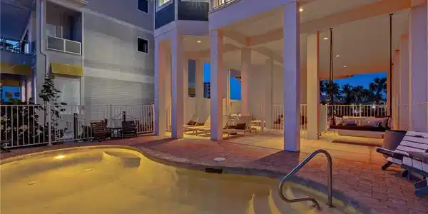 Image 3: Pool at dusk featuring an outdoor pool, a patio area, and a balcony