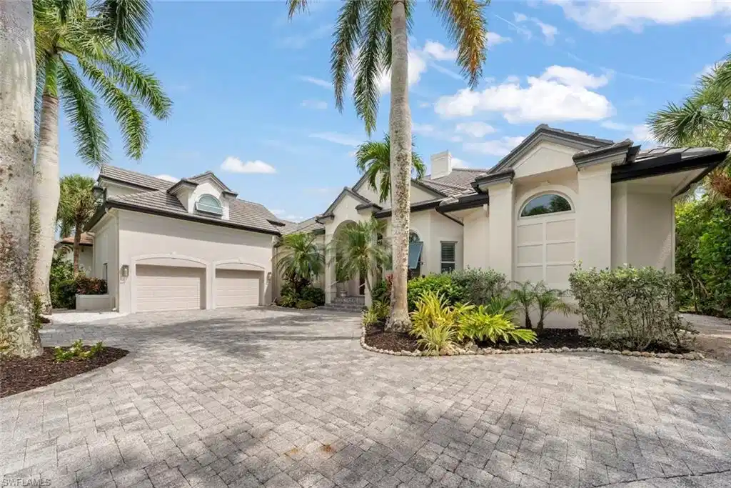Image 1: Stucco exterior with a paver driveway, two-car garage, and a tiled roof