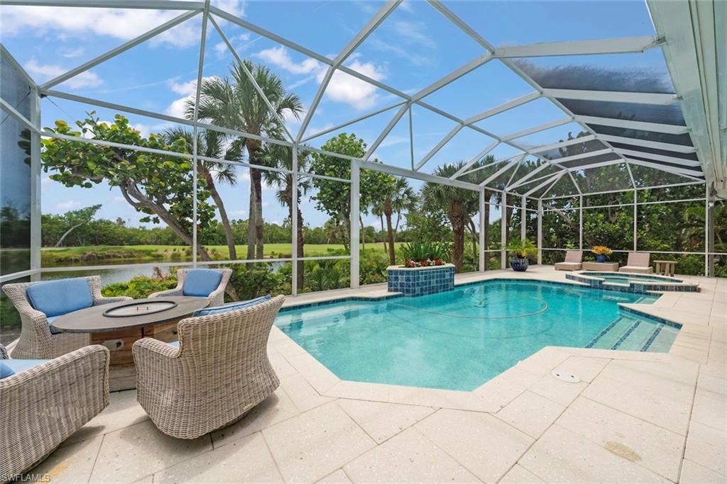 Image 2: Screened outdoor living area featuring a rectangular pool and integrated spa