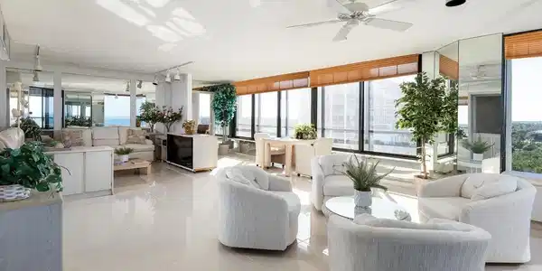 Image 3: Tiled living room featuring ceiling fan, a wall of windows, and a healthy amount of sunlight