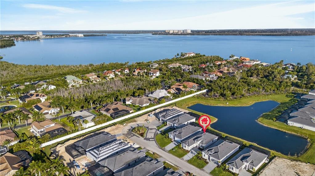 Image 2: Aerial view of residential area featuring a nearby body of water