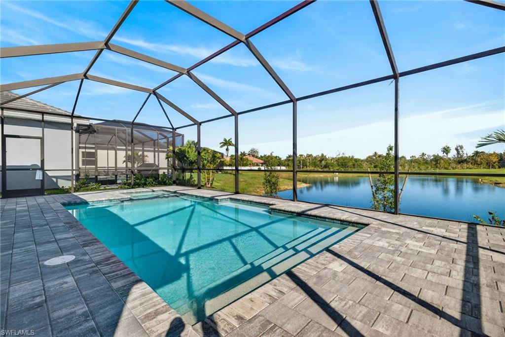 Image 4: Swimming pool featuring a sunroom, glass enclosure, a water view, and a jacuzzi