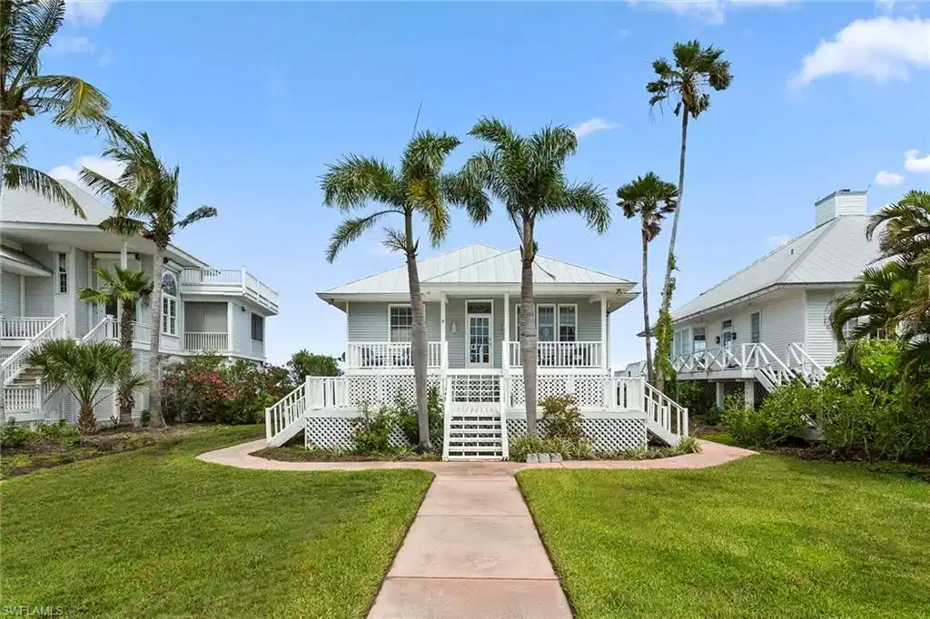 Image 1: View of front of property with a front yard, stairway, a metal roof, and covered porch