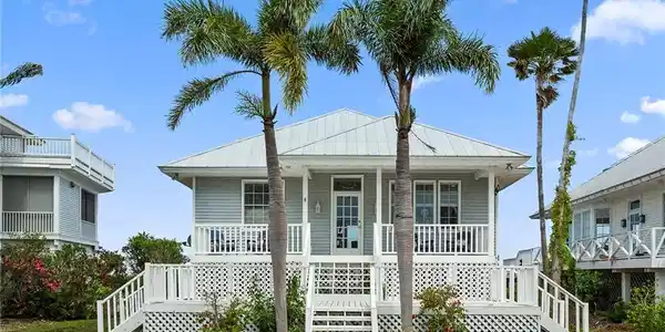 Image 2: View of front of property with stairs, a porch, and a metal roof