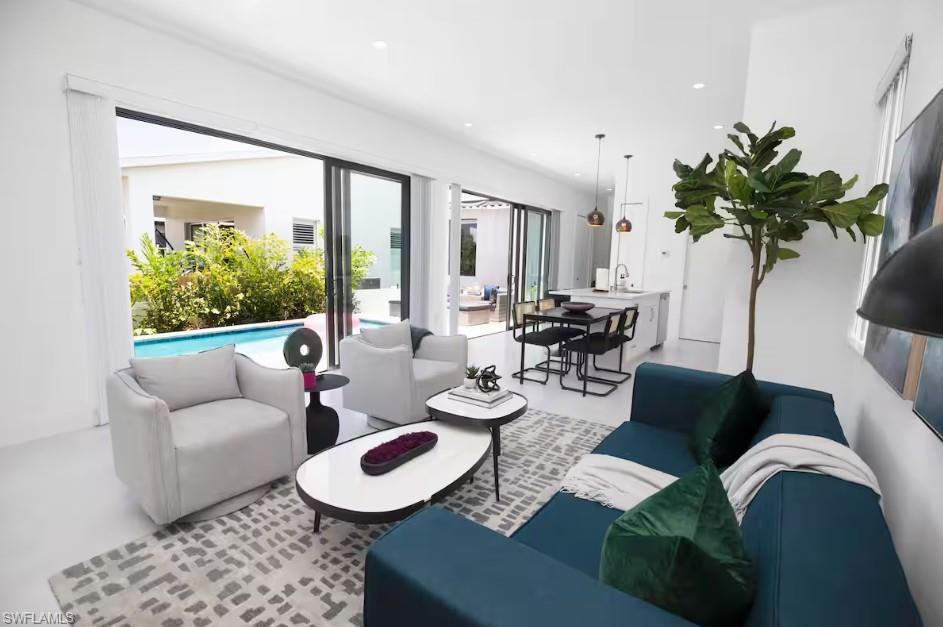 Image 2: Open-concept living space with swimming pool view