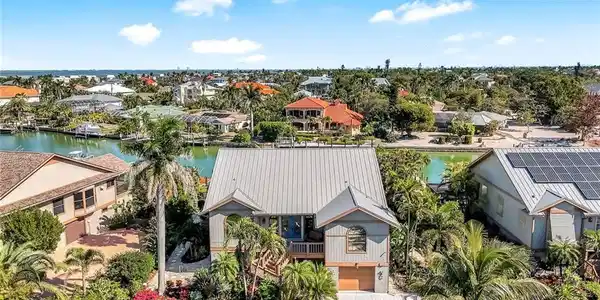 Image 4: Aerial view of residential area with a nearby body of water