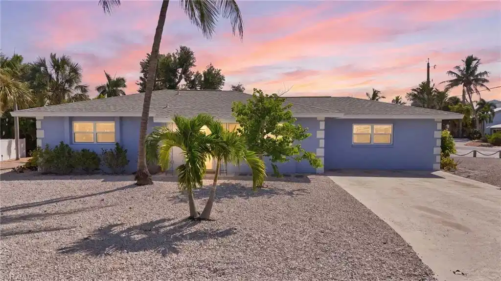 Image 1: Ranch-style residence featuring a pale blue exterior with white trim accents and a gray shingled roof