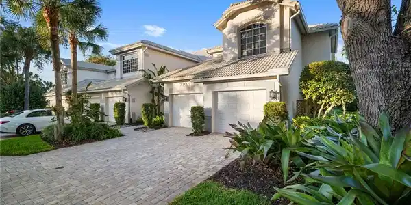 Image 2: Mediterranean home with stucco siding, a tile roof, decorative driveway, and an attached garage