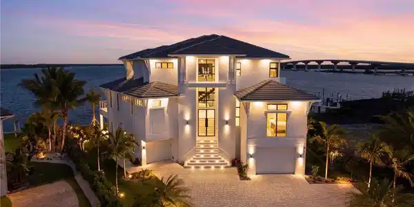 Image 2: Modern home featuring an attached garage, a tile roof, driveway, and stucco siding - Virtually Edited Image