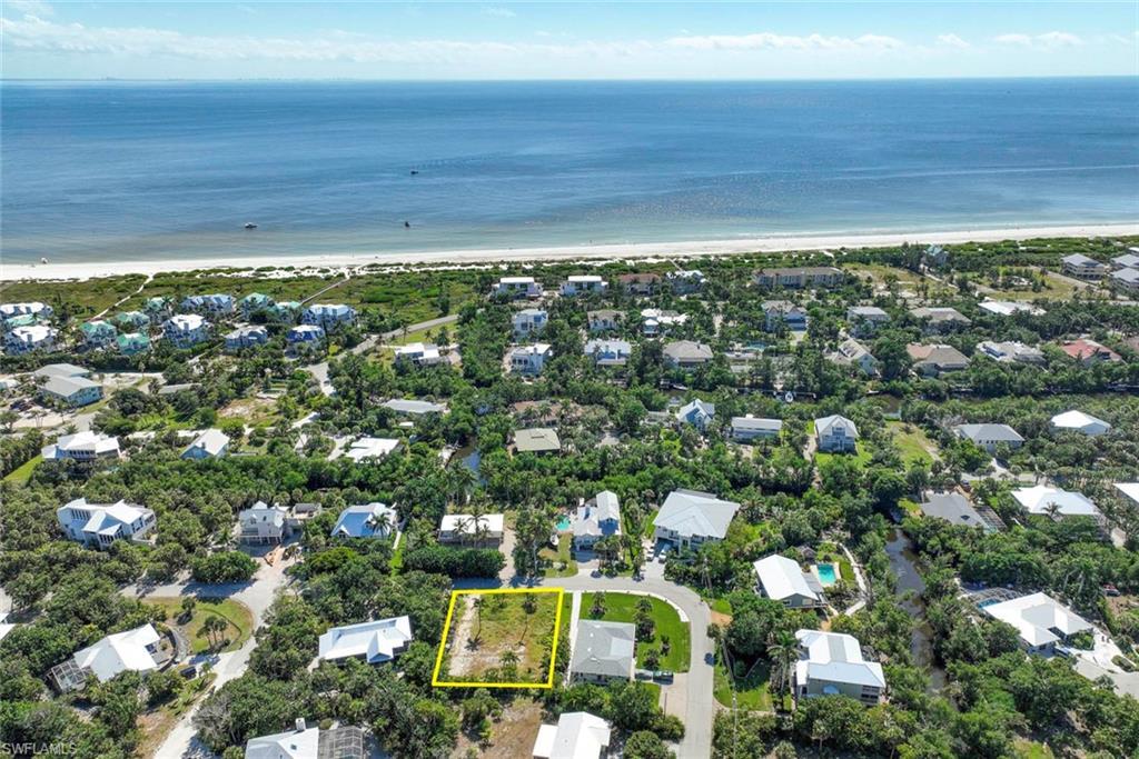 Image 1: Aerial perspective of suburban area with waterfront with a beach and property boundaries highlighted