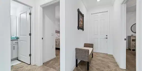 Image 4: Hall with light tile patterned floors and crown molding