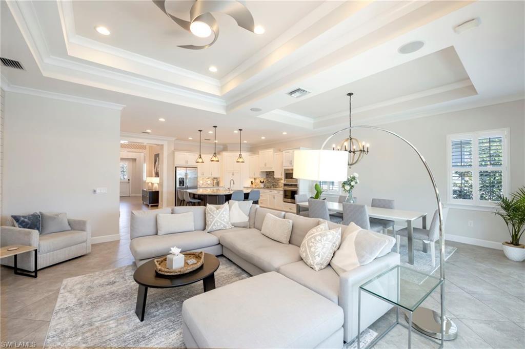 Image 3: Living room has layered tray ceilings with crown moulding