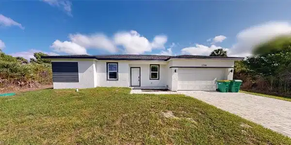 Image 2: Ranch-style house with a front lawn, stucco siding, an attached garage, and decorative driveway