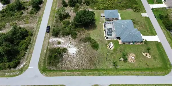 Image 3: Single-story residence featuring a screened-in pool, an attached garage, and a detached outbuilding