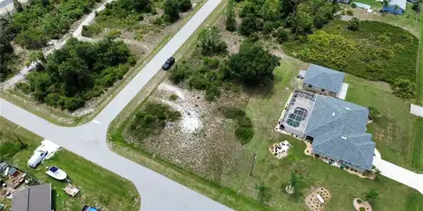 Image 4: Aerial perspective showcasing a corner lot with undeveloped land