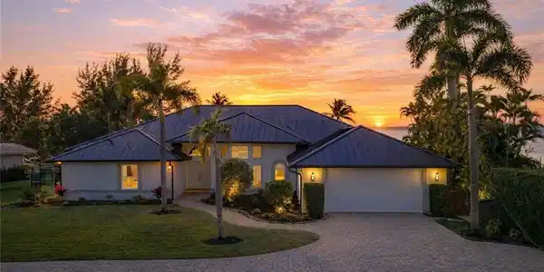 Image 3: View of front facade featuring driveway, a front yard, a standing seam roof, and a garage
