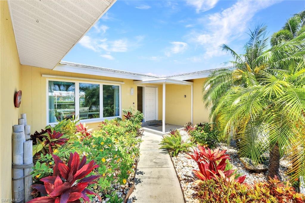 Image 3: Tropical, colorful landscaping greets you at your entry.