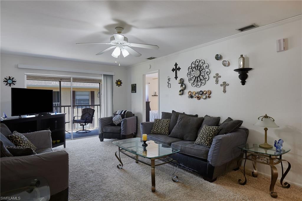 Image 3: Living area featuring carpet floors, crown molding, and ceiling fan