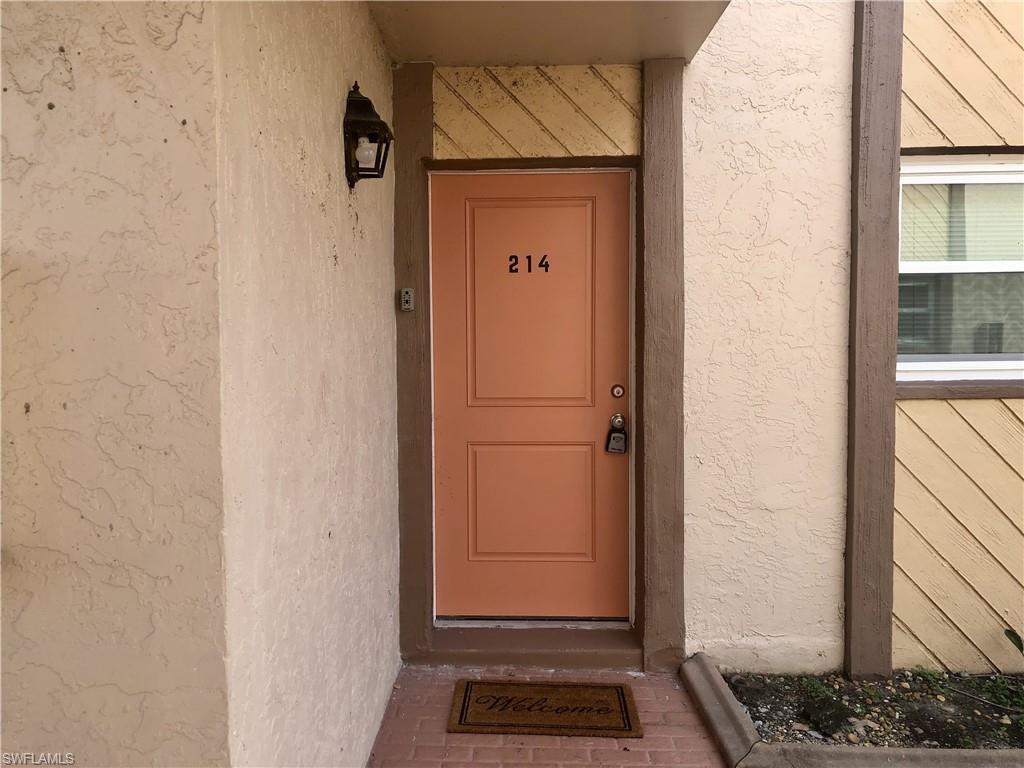 Image 2: Entry door featuring a panel design, a numeric address, and a wall-mounted exterior light fixture