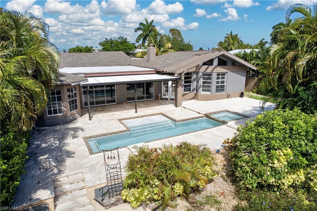 Image 1: The property features a large patio area with a swimming pool and an integrated spa