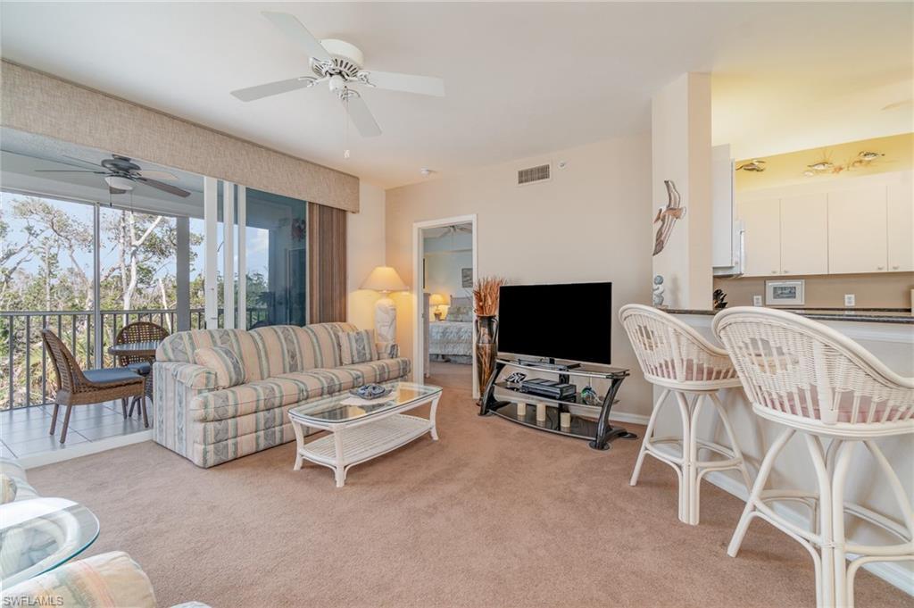 Image 2: Carpeted living room with ceiling fan
