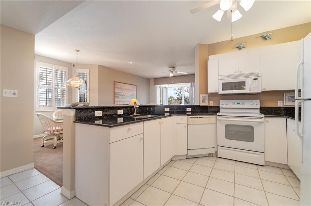 Image 3: Kitchen featuring sink, white cabinets, white appliances, and kitchen peninsula