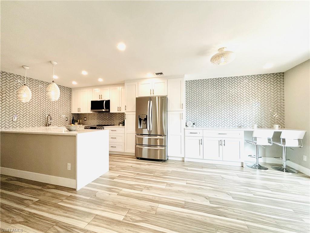 Image 4: Living room featuring light wood-type tile flooring and recessed lighting