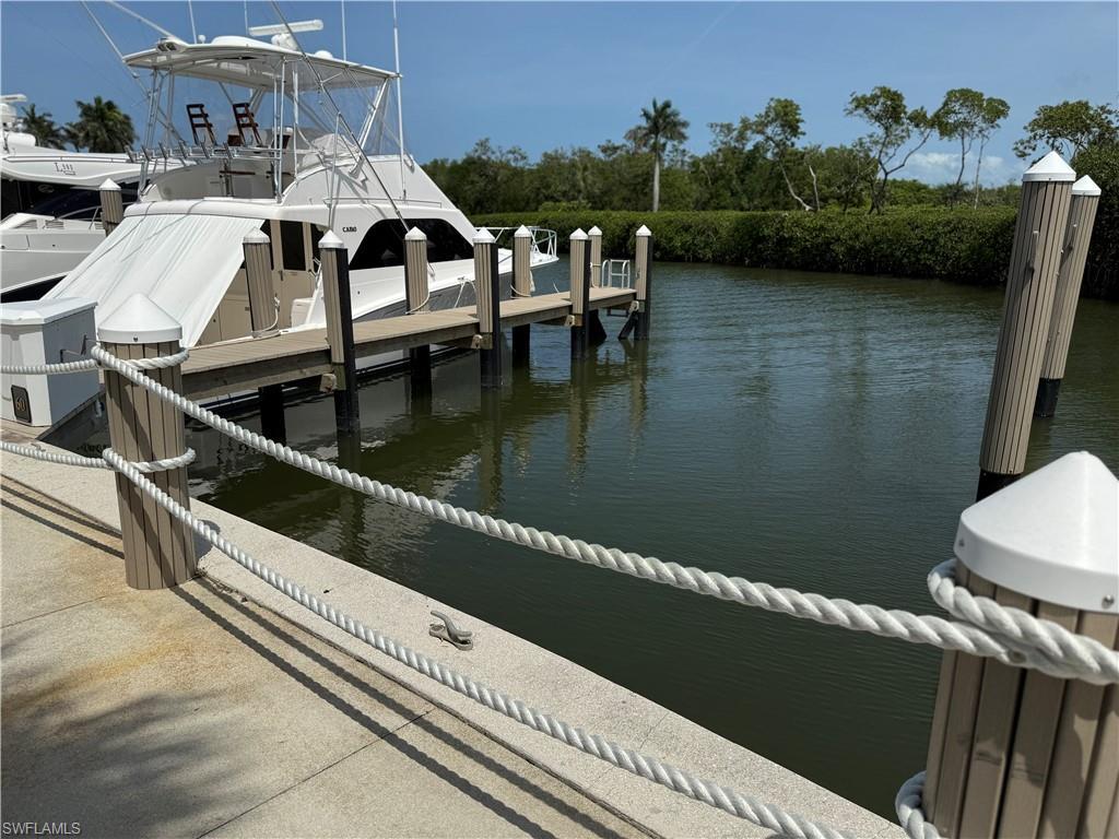 Image 2: Waterfront property featuring a private dock, composite pilings, and a concrete pathway with rope railing