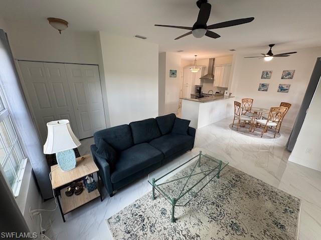 Image 1: Living area with light marble finish flooring and ceiling fan