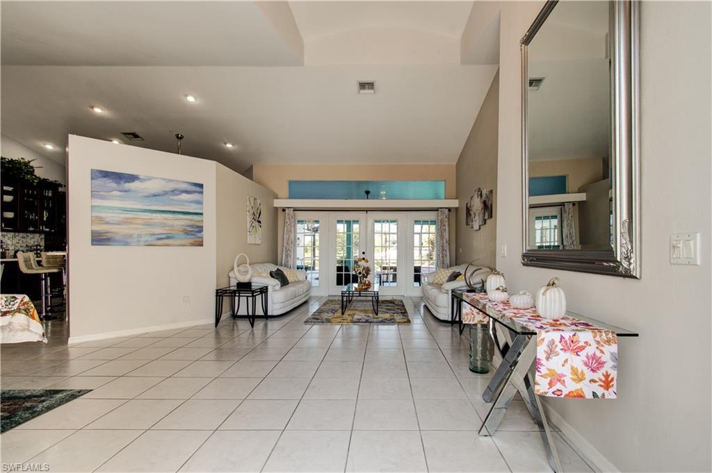 Image 3: Living area featuring vaulted ceiling, french doors, light tile patterned flooring, and recessed lighting