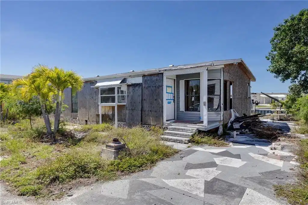 Image 1: Single-story structure with a covered entry, an enclosed porch, and a patterned concrete driveway