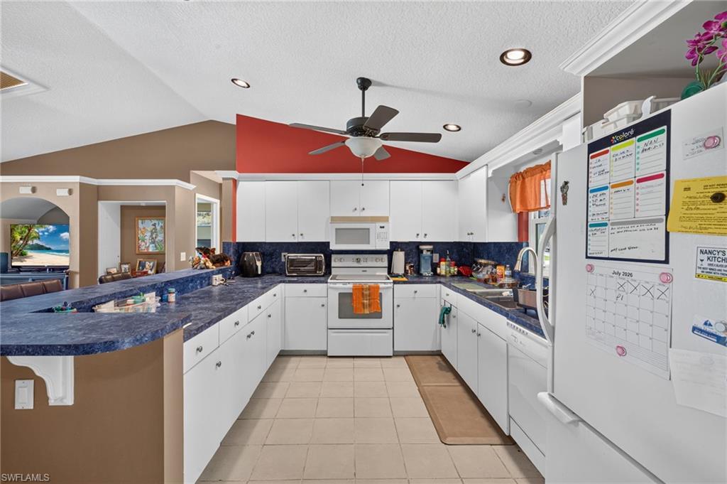Image 4: Kitchen featuring white cabinetry, blue countertops, recessed lighting, and tile flooring