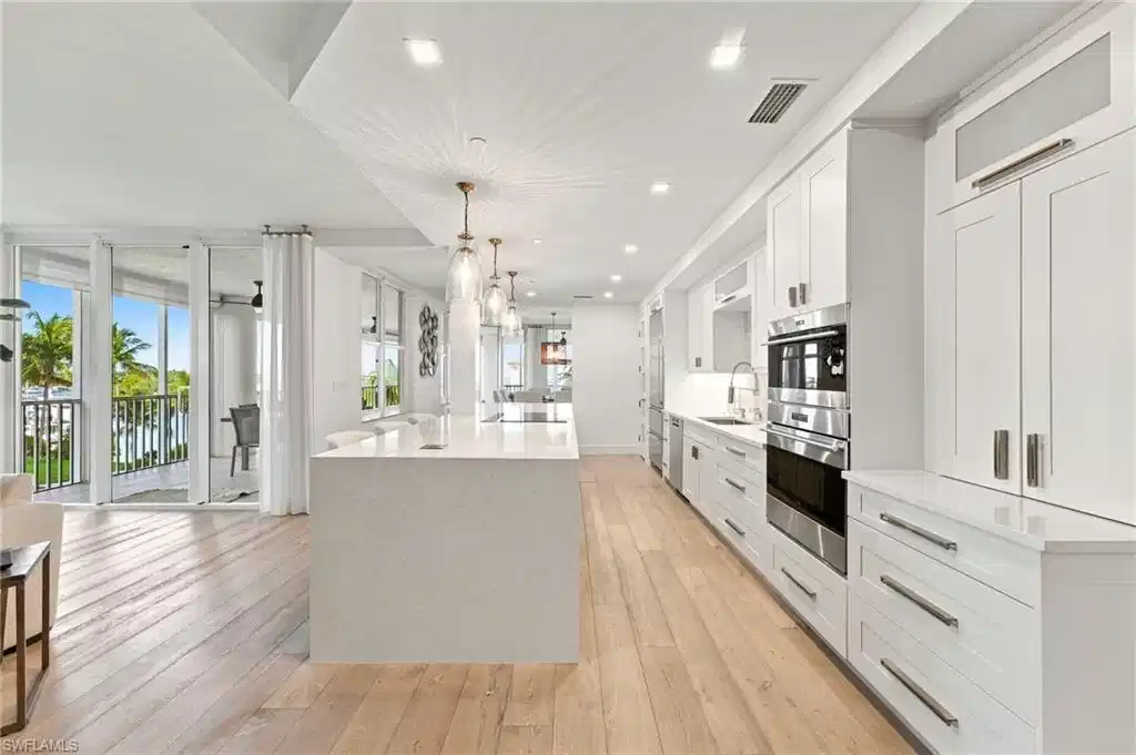 Image 1: Integrated kitchen and living area featuring wood-finish flooring