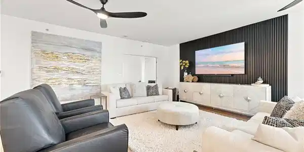 Image 3: Recessed lighting, wood-finish flooring, and black accent wall with vertical paneling