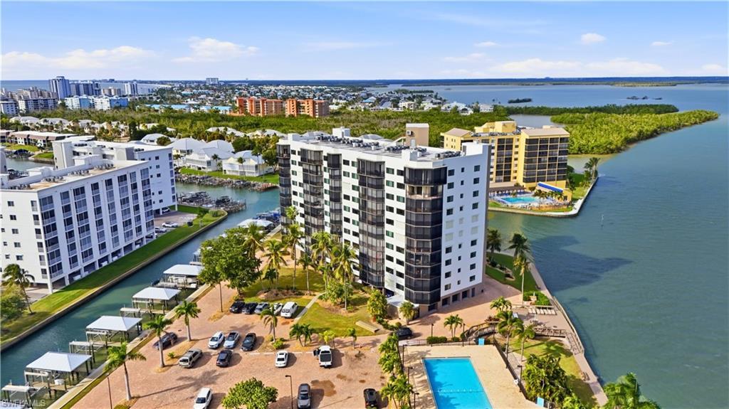 Image 4: Aerial view featuring Estero Bay & canal with boat docks and Harbour Pointe, pool and parking, boat docks/lifts on canal- Virtually Edited Image