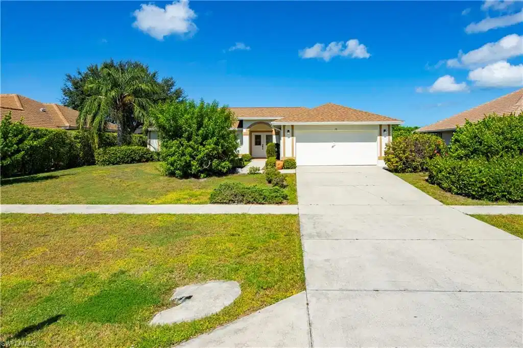 Image 1: Single-story residence with a concrete driveway, attached two-car garage, and established landscaping