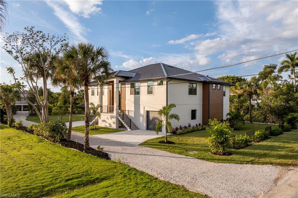 Image 3: Contemporary home with driveway, a front yard