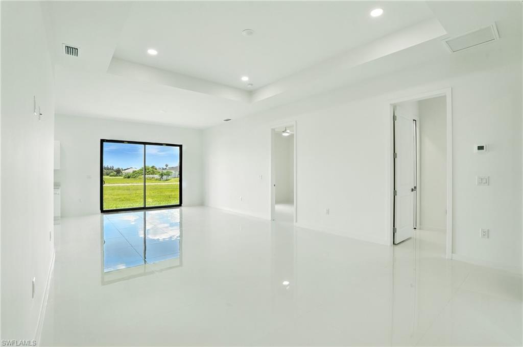 Image 4: Empty room featuring a raised ceiling, recessed lighting, and light tile patterned floors