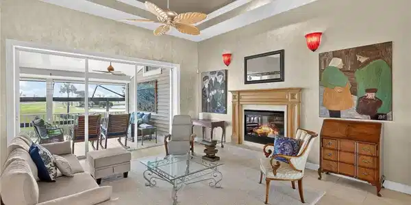 Image 3: Living area featuring a tray ceiling, light tile patterned flooring, and a sunroom