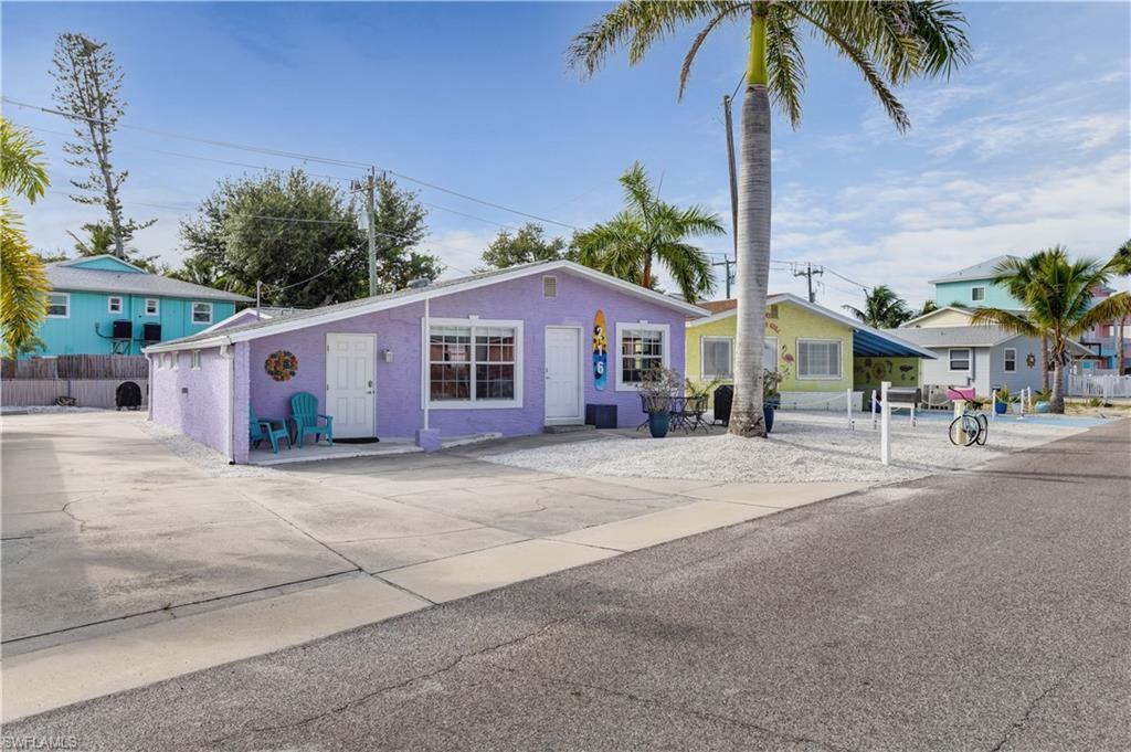Image 1: Purple exterior with white trim, featuring a concrete driveway and an additional side entrance