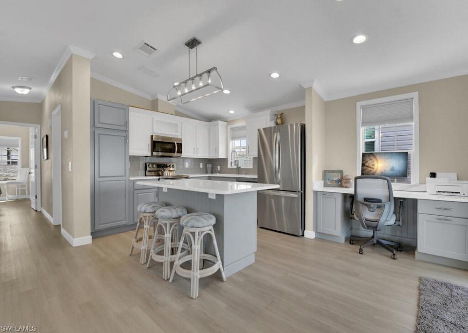 Image 3: Kitchen featuring stainless steel appliances, backsplash, plenty of natural light, gray cabinetry, and light hardwood / wood-style flooring