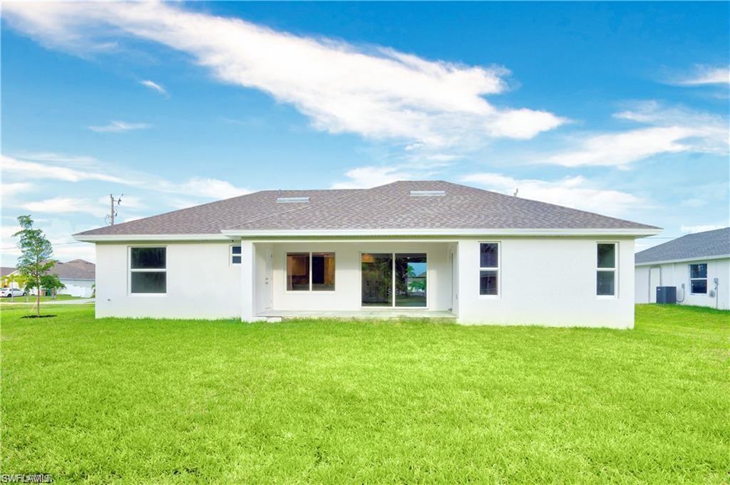 Image 2: Rear view of house featuring stucco siding, a lawn, a patio area, and a shingled roof