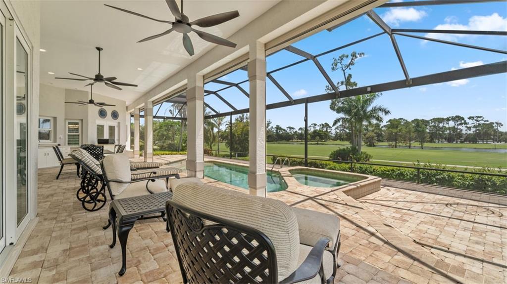 Image 4: Screened lanai featuring a swimming pool and attached spa, paver patio, and multiple ceiling fans