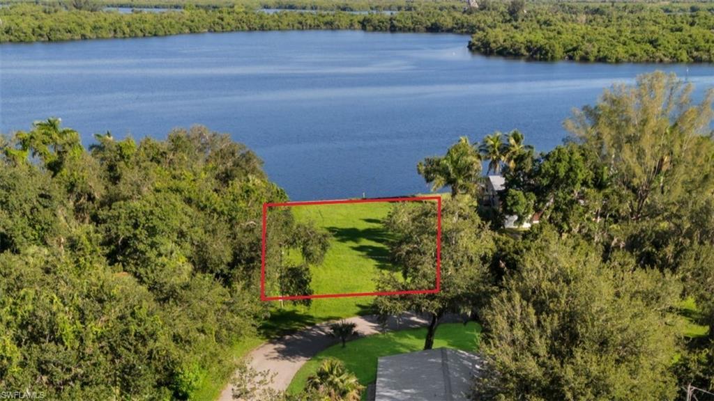Image 2: Aerial overview of property's location featuring property boundaries highlighted and a nearby body of water