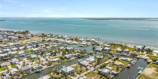 Image 2: Aerial perspective of suburban area with a nearby body of water