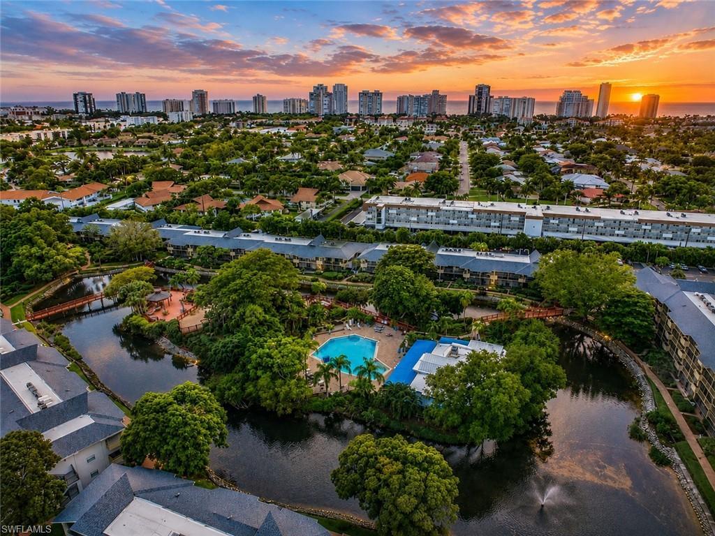 Image 2: Community with multiple residential buildings, a central water feature, and extensive mature landscaping