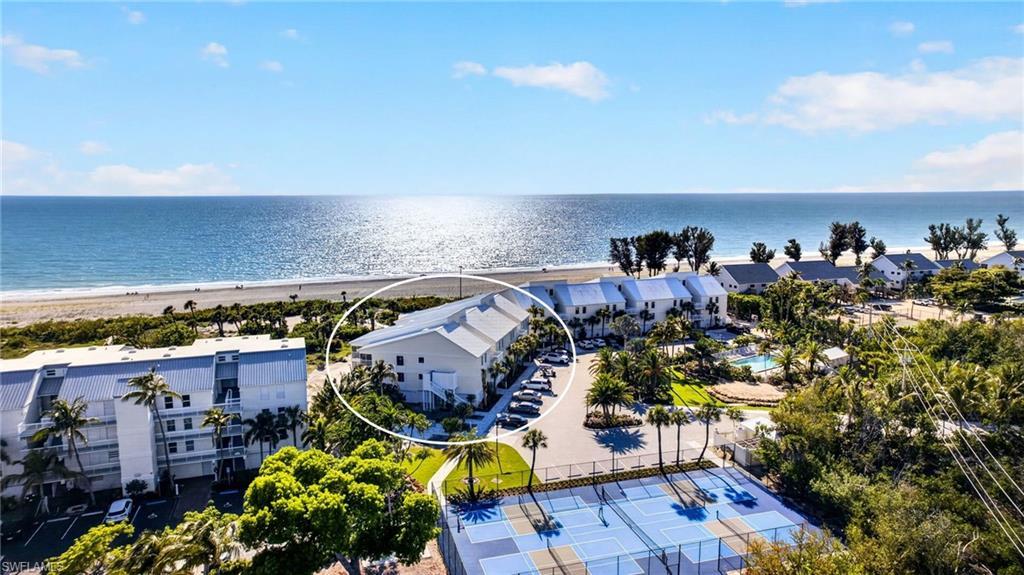 Image 1: Beachfront property featuring multiple balconies, a coastal design, and a direct beach access path