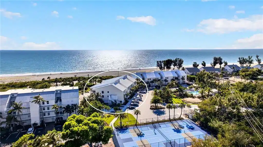 Image 1: Beachfront property featuring multiple balconies, a coastal design, and a direct beach access path