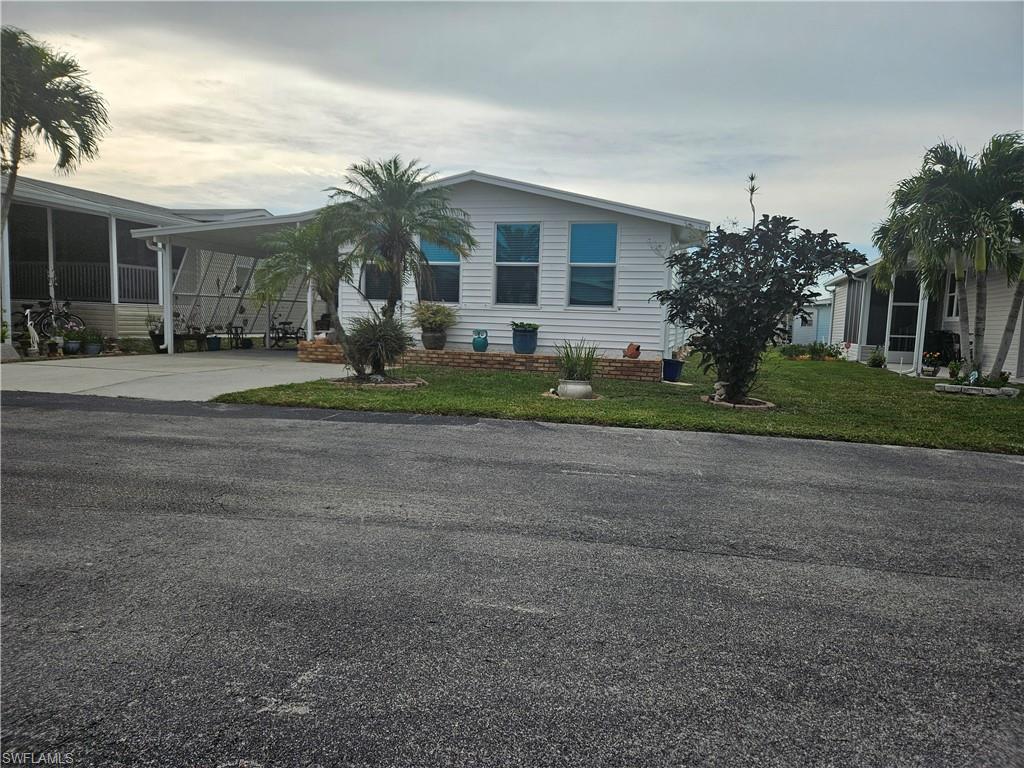 Image 2: View of front of property featuring a front lawn and a carport